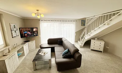 Wohnzimmer mit gemütlicher Couch, Smart-TV, DAB Radio, Blu-Ray-Player sowie ein direkter Zugang über die Schiebetür auf die Terrasse