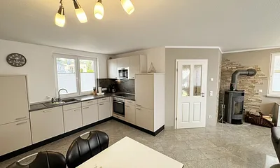 Küchenzeile mit Backofen, Ceranfeld, Kühlschrank, Mikrowelle, Geschirrspüler, Spüle und diverse Küchenutensilien