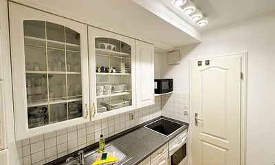 Landhausküche mit Ceran-Kochfeld, Backofen, Kühlschrank mit Gefrierfach, Mikrowelle, Kaffeemaschine, Toaster, Wasserkocher und anderen praktischen Helfern