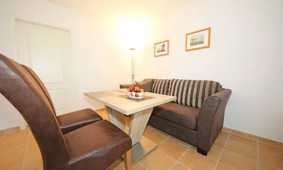 Wohnbereich mit gemütlicher Couch, Leselampe, mediterrane Vollholzmöbel, Kleiderschrank