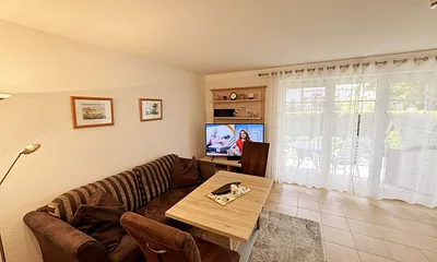 Wohnbereich mit gemütlicher Couch, Leselampe, mediterrane Vollholzmöbel, Kleiderschrank