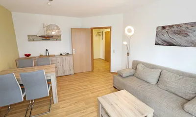 Wohnbereich mit hochwertiger Schlafcouch (1,60 m x 2,00 m, Aufbettungsmöglichkeit für 3/4 Person), Couchtisch, Leselampe, Sideboard mit Smart-TV mit Sky