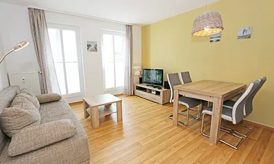 Wohnbereich mit hochwertiger Schlafcouch (1,60 m x 2,00 m, Aufbettungsmöglichkeit für 3/4 Person), Couchtisch, Leselampe, Sideboard mit Smart-TV mit Sky