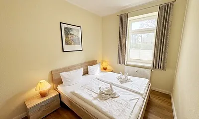 Schlafzimmer mit Doppelbett (1,80 m x 2,00 m), großen Kleiderschrank und Nachttischablagen