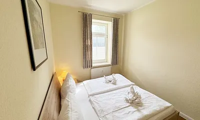 Schlafzimmer mit Doppelbett (1,80 m x 2,00 m), großen Kleiderschrank und Nachttischablagen