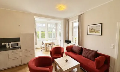 offener Wohnbereich mit Sofa, Sessel, Couchtisch und Sideboard, Flachbild-TV, Blu-Ray-Player und Mini-Stereo-Anlage mit USB-Anschluss