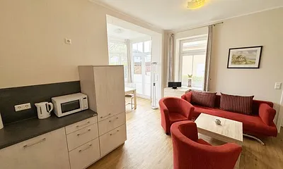 Küchenzeile mit Cerankochfeld, Backofen, Geschirrspüler, Kühlschrank, Gefrierfach, Kaffeemaschine, Mikrowelle, Wasserkocher, Toaster und diversen Küchenutensilien