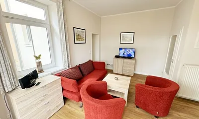 offener Wohnbereich mit Sofa, Sessel, Couchtisch und Sideboard, Flachbild-TV, Blu-Ray-Player und Mini-Stereo-Anlage mit USB-Anschluss
