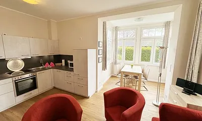 offener Wohnbereich mit Sofa, Sessel, Couchtisch und Sideboard, Flachbild-TV, Blu-Ray-Player und Mini-Stereo-Anlage mit USB-Anschluss