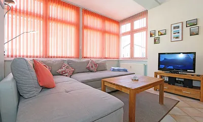 Wohnbereich mit Couch (Ausziehfunktion zum Doppelbett (1,60 m x 2,00 m), Kleiderschrank, Sessel, Couchtisch, kleinem Beistelltisch, Flachbild-TV, DVD-Player sowie Mini-Stereo-Anlage mit USB-Anschluss