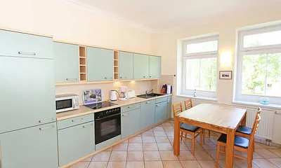 Küchenzeile mit Cerankochfeld, Backofen, Geschirrspüler, Mikrowelle, Kühlschrank, Gefrierfach, Kaffeemaschine, Wasserkocher, Toaster und diversen Küchenutensilien