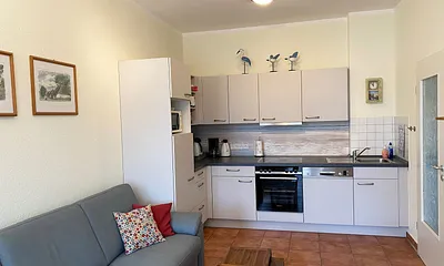 offener Wohnbereich mit Sofa, Sessel, Couchtisch, Sideboard, Leselampe, Smart-TV, DVD-Player sowie Mini-Stereo-Anlage mit USB-Anschluss und DAB-Radio