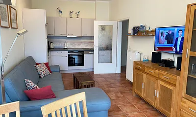 offener Wohnbereich mit Sofa, Sessel, Couchtisch, Sideboard, Leselampe, Smart-TV, DVD-Player sowie Mini-Stereo-Anlage mit USB-Anschluss und DAB-Radio