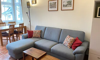 offener Wohnbereich mit Sofa, Sessel, Couchtisch, Sideboard, Leselampe, Smart-TV, DVD-Player sowie Mini-Stereo-Anlage mit USB-Anschluss und DAB-Radio