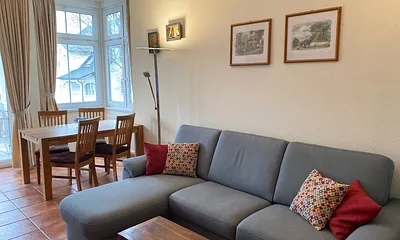 offener Wohnbereich mit Sofa, Sessel, Couchtisch, Sideboard, Leselampe, Smart-TV, DVD-Player sowie Mini-Stereo-Anlage mit USB-Anschluss und DAB-Radio