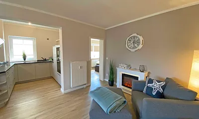 Wohnzimmer mit gemütlicher Couch, Couchtisch, Leselampe, Sessel, Hocker, Lowboard, Smart-TV, Blu-Ray Player, Teufel-Musikanlage mit Radio, DAB Radio, CD-Spieler, USB-Anschluss und Bluetooth