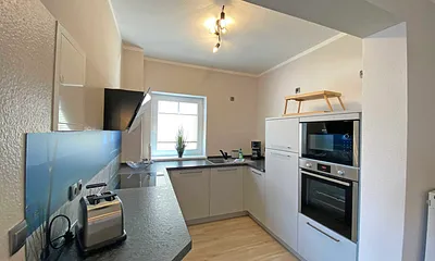 moderne Küchenzeile mit Geschirrspüler, Toaster, Wasserkocher, Kaffeemaschine, 4 Zonen-Kochfeld, Backofen, integrierte Mikrowelle, Kühl-Gefrierkombination und hochwertigen Granitarbeitsflächen