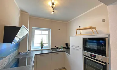 moderne Küchenzeile mit Geschirrspüler, Toaster, Wasserkocher, Kaffeemaschine, 4 Zonen-Kochfeld, Backofen, integrierte Mikrowelle, Kühl-Gefrierkombination und hochwertigen Granitarbeitsflächen