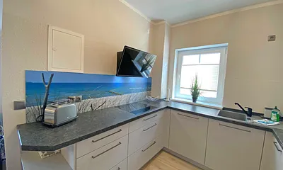 moderne Küchenzeile mit Geschirrspüler, Toaster, Wasserkocher, Kaffeemaschine, 4 Zonen-Kochfeld, Backofen, integrierte Mikrowelle, Kühl-Gefrierkombination und hochwertigen Granitarbeitsflächen