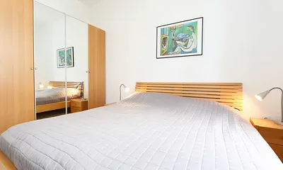Schlafzimmer mit Doppelbett (1,80 m x 2,00 m), Nachttischkonsolen und Kleiderschrank
