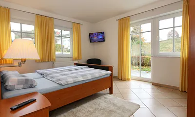 Schlafzimmer mit Doppelbett (1,60 m x 2,00 m), verstellbare Lattenroste, 2 Nachtschränken, Flachbild-TV und Kleiderschrank / Von hier aus blicken Sie auf das Naturschutzgebiet 