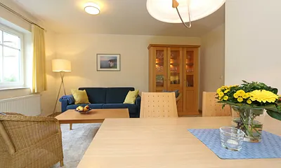 Wohnbereich mit Sofa, Sessel, Couchtisch, Vitrine, Leselampe, Flatscreen-TV mit DVD-Player, Stereoanlage mit CD und eine kleine Auswahl an Gesellschaftsspielen