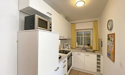 helle Küchenzeile mit Ceranfeld, Backofen, Geschirrspüler, Mikrowelle, Kühlschrank mit Gefrierfach, Kaffeemaschine, Senseo Kaffeeautomat, Toaster, Wasserkocher und diverse Küchenutensilien