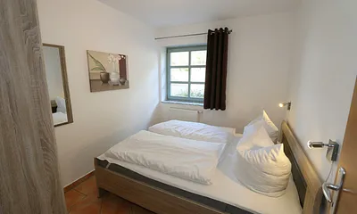 Schlafzimmer mit Doppelbett (1,60 m x 2,00 m), Kleiderschrank und Außenrollos