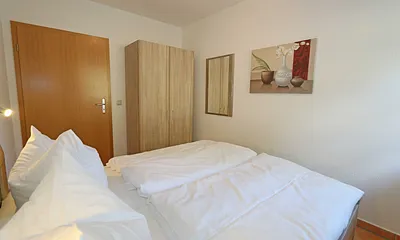 Schlafzimmer mit Doppelbett (1,60 m x 2,00 m), Kleiderschrank und Außenrollos