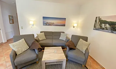 moderner Wohnbereich mit gemütlicher Polsterecke, Couchtisch, Leselampe, Flachbild-TV, DVD-Player und eine Mini-Stereo-Anlage