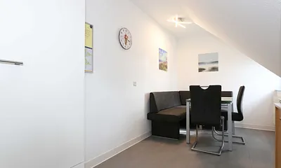 Essbereich mit zwei Stühle, Glastisch sowie eine Sitzecke