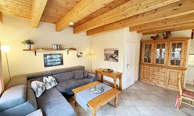 Wohnbereich mit Couchecke (Aufbettung für 5. Person, 1,30 m x 1,90 m), Couchtisch, Leselampe, Bücherregal mit kleiner Buchauswahl, Smart-TV, DVD-Player und kleiner Musikanlage