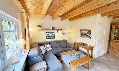 Wohnbereich mit Couchecke (Aufbettung für 5. Person, 1,30 m x 1,90 m), Couchtisch, Leselampe, Bücherregal mit kleiner Buchauswahl, Smart-TV, DVD-Player und kleiner Musikanlage