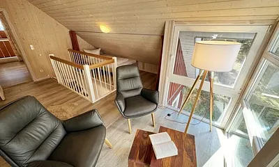 lichtdurchflutete Galerie mit bodentiefer Fensterfront, gemütliche Sitzgruppe (mit Blick in den Kiefernwald) und ein franzöisches Bett (1,40 m x 2,00 m unter einer Dachschräge)