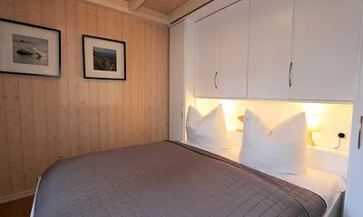 Schlafzimmer mit Doppelbett (1,60 m x 2,00 m), Nachttischablagen und Kleiderschrank