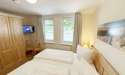 1. Schlafzimmer mit Doppelbett und Kleiderschrank sowie TV