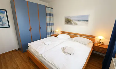 Schlafzimmer mit Doppelbett und Kleiderschrank