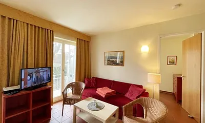 Wohnbereich mit komfortabler Schlafcouch (1,60m x 2,00m), Leselampe und LED Fernseher