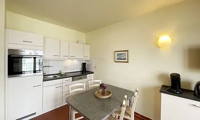 Küchenzeile mit Cerankochfeld, Spülmaschine, Backofen, Kaffeemaschine, Wasserkocher, Toaster, Kühlschrank und allen wichtigen Küchenutensilien