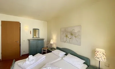 Schlafzimmer mit Doppelbett, 7-Zonen Matratzen (2 x 0,90 m x 2,00 m), Kleiderschrank und Kommode mit Spiegel