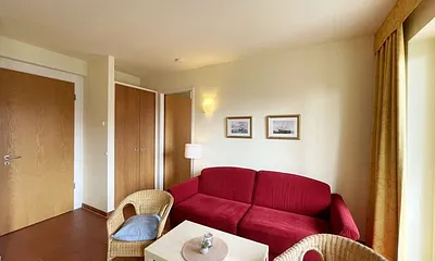 Wohnbereich mit komfortabler Schlafcouch (1,60m x 2,00m), Leselampe und LED Fernseher