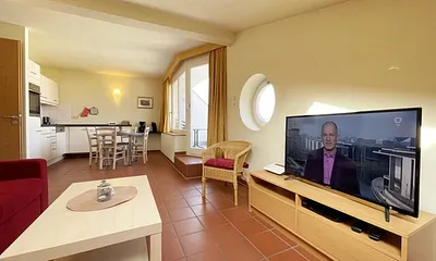 Wohnbereich mit komfortabler Schlafcouch (1,60m x 2,00m), Leselampe und LED Fernseher