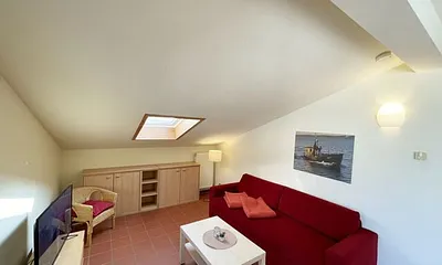 Wohnbereich mit komfortabler Schlafcouch (1,60m x 2,00m), Leselampe und LED Fernseher 