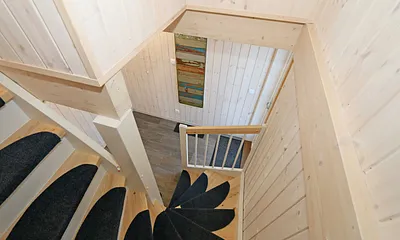 Zugang zum Obergeschoss durch eine Kiefernholztreppe 