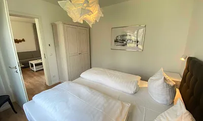 Schlafzimmer mit einem Boxspringbett (1,80 m x 2,00 m), Beistelltischen mit Nachtlicht, einem Kleiderschrank sowie lichtdichte Vorhänge und Insektenschutzgitter