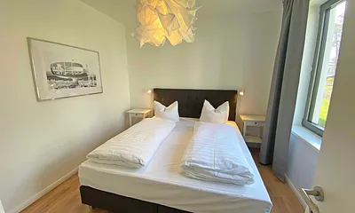Schlafzimmer mit einem Boxspringbett (1,80 m x 2,00 m), Beistelltischen mit Nachtlicht, einem Kleiderschrank sowie lichtdichte Vorhänge und Insektenschutzgitter