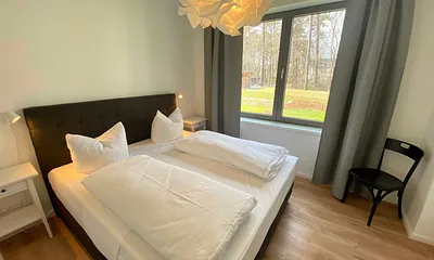 Schlafzimmer mit einem Boxspringbett (1,80 m x 2,00 m), Beistelltischen mit Nachtlicht, einem Kleiderschrank sowie lichtdichte Vorhänge und Insektenschutzgitter