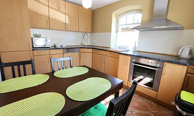 Küche mit Geschirrspüler, Backofen mit Ceranfeld, Abzugshaube, Kühlschrank mit Eisfach, Mikrowelle, Kaffeemaschine, Toaster, Wasserkocher und diversen Küchenutensilien