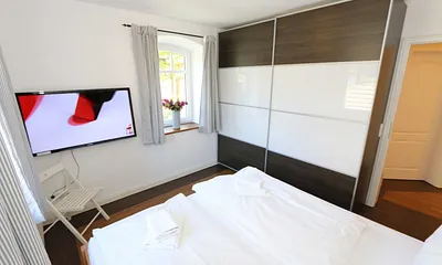 Schlafzimmer mit Doppelbett (1,80 m x 2,00 m), verstellbaren Lattenrosten, großem Kleiderschrank und Flachbild-TV
