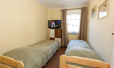 Schlafzimmer mit 2 Liegen (je 0,70 m x 1,80 m) - zu einem Doppelbett zusammenstellbar, Kommode und Flachbild-TV